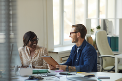 Smiling African American Woman Talking to Boss in Office