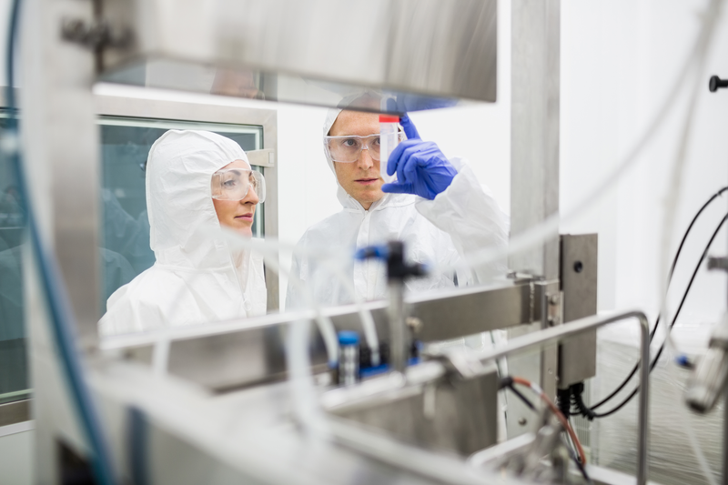 Scientists working with large vat in the lab